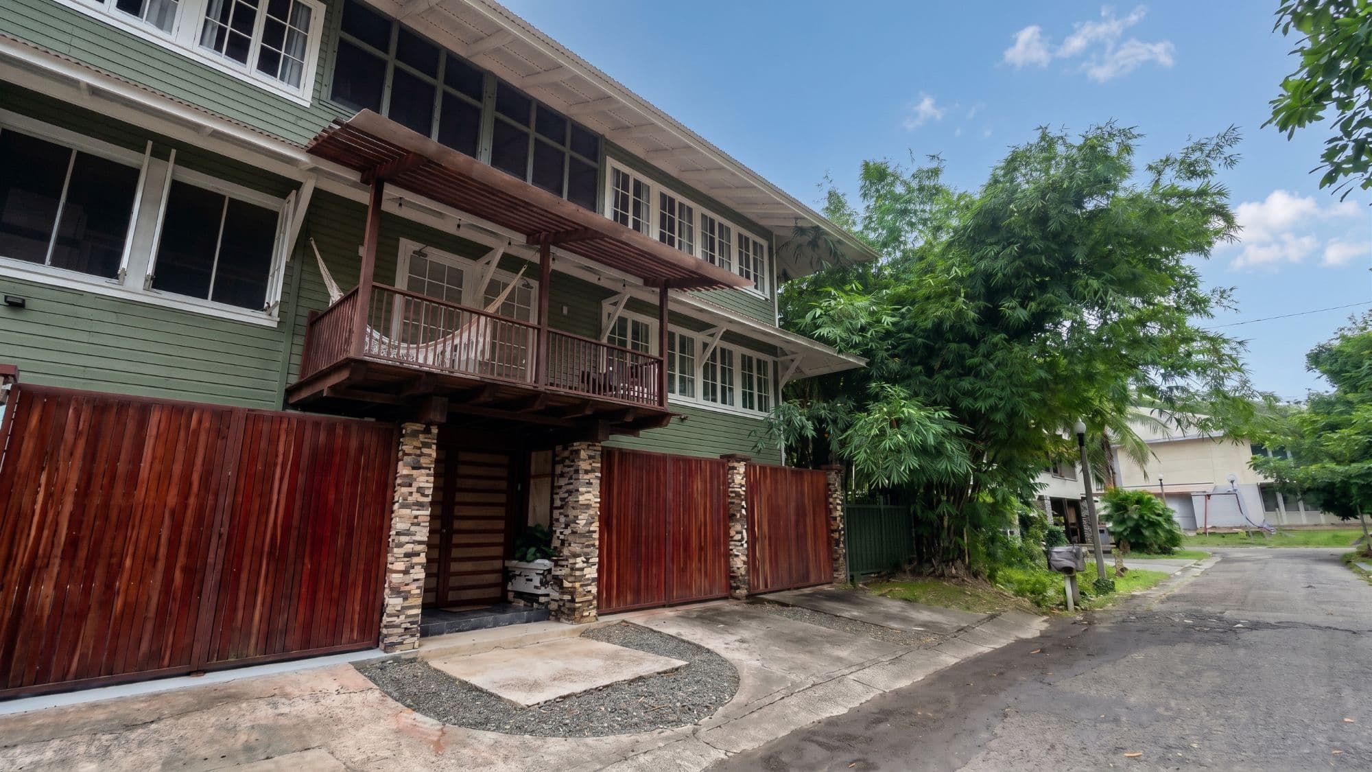Fachada de madera de Casa Randa en Diablo Heights, con entablado verde y cerca de caoba